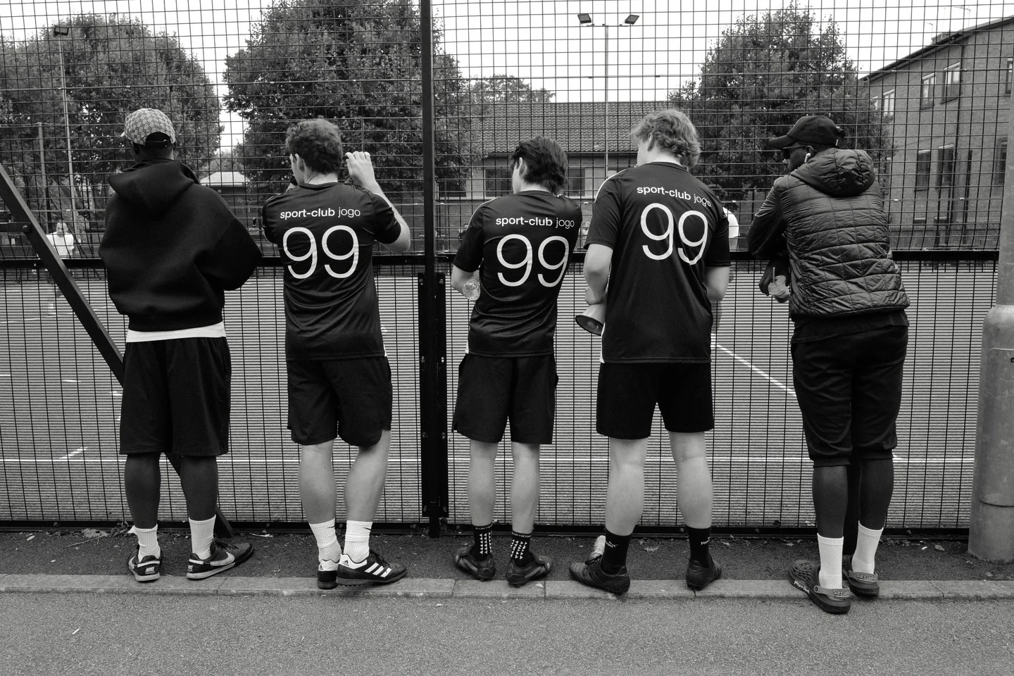 Sport-Club Jogo players wearing number 99 shirts beside the pitch.